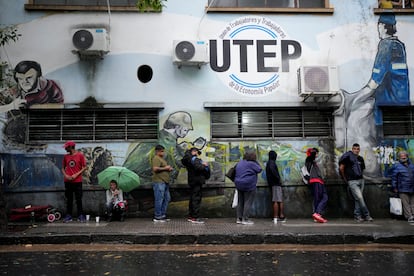 Varias personas esperan en fila para acceder a un comedor social, en marzo de 2024 en Buenos Aires.