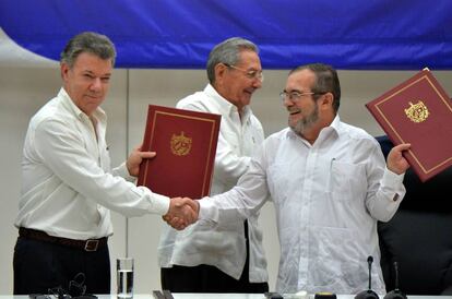 El presidente de Colombia Juan Manuel Santos y Timochenko, líder de las FARC, en presencia del presidente cubano Raúl Castro, en la firma del acuerdo de paz.