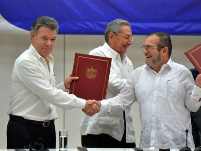 El presidente de Colombia Juan Manuel Santos y Timochenko, líder de las FARC, en presencia del presidente cubano Raúl Castro, en la firma del acuerdo de paz.