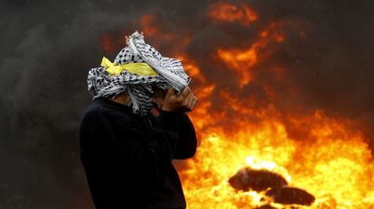 Un manifestante palestino se protege del fuego de una barricada en una protesta contra los asentamientos israelíes en la localidad de Kofr Qadom, cerca de la ciudad cisjordana de Nablus.