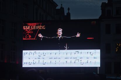 En una pantalla se proyectaban los textos y la música de los corales para que pudieran cantarlos los asistentes al concierto de la Marktplatz.