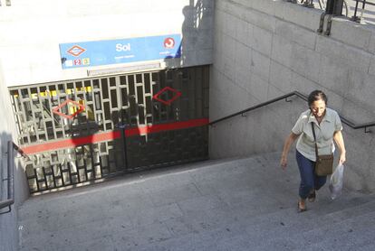 Una mujer sube las escaleras de una de las bocas de acceso a la estación de metro y Cercanías de Sol, que ha sido cerrada. Los trenes han dejado de parar allí a las 18.30.