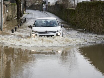 Un vehículo atraviesa una de las zonas donde el río Arga se ha desbordado a su paso por Pamplona, este lunes.