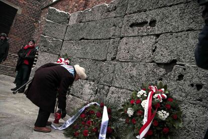 Un sobreviviente del Holocausto pone una corona de flores en el muro de la muerte, durante el homenaje a las víctimas del genocidio judío, cuando se cumple el 69 aniversario de la liberación de Auschwitz.