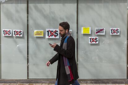 Un hombre pasa junto a la sede de la Agencia de Salud Pública de Cataluña, adornada con carteles en contra de la aplicación del artículo 155 de la Constitución y en apoyo a los presos políticos.