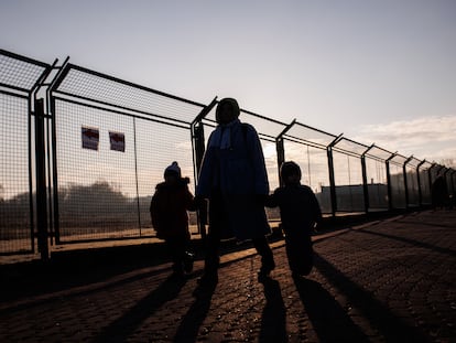 Un adulto y dos niños refugiados en el paso fronterizo de Przemysl (Polonia), en febrero de 2022.