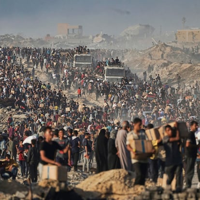 Palestinians carry sacks and boxes of food and humanitarian aid unloaded from a World Food Program convoy that had been heading to Gaza City, in the northern Gaza Strip, Monday, June 16, 2025. (AP Photo/Jehad Alshrafi)