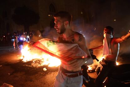 Unos manifestantes, la noche de este jueves durante los disturbios en Beirut.