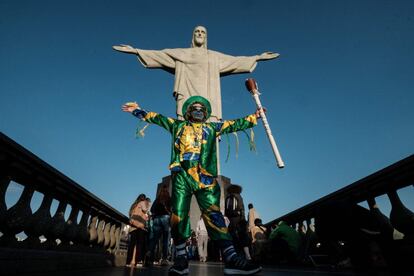 Un hombre vestido con los colores de la bandera de Brasil posa delante de la estatua del Cristo Redentor en Río de Janeiro (Brasil).