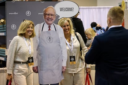 Asistentes a la junta de accionistas de Warren Buffett posan con una imagen del inversor en Omaha (Nebraska).