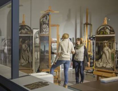 Los restauradores del 'Políptico de la Adoración del Cordero Místico', trabajando dentro de una habitación acristalada en el Museo de Bellas Artes de Gante.