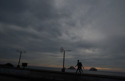 Una pareja camina frente a una playa en Mazatlán, mientras 'Orlene' se dirige a colisionar con la costa noroeste del Pacífico de México.