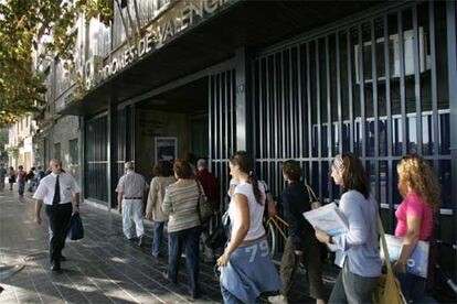 Un grupo de alumnos, ayer, frente a la puerta de la Escuela Oficial de Idiomas de Valencia.