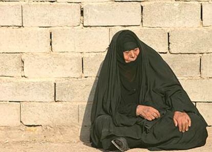 Una anciana del barrio bagdadí de Ciudad Sáder junto a una pared durante el funeral de su nieto.