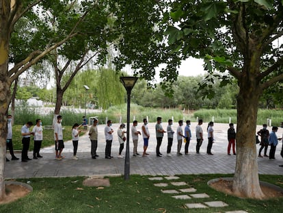 Un grupo de personas guarda cola para hacerse la prueba del coronavirus, en un parque del sur de Pekín.