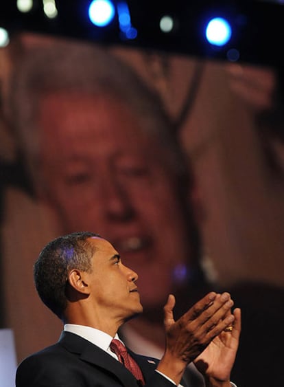 Obama aplaude a Bill Clinton, cuya imagen aparece en la pantalla a su espalda, el miércoles en la convención.