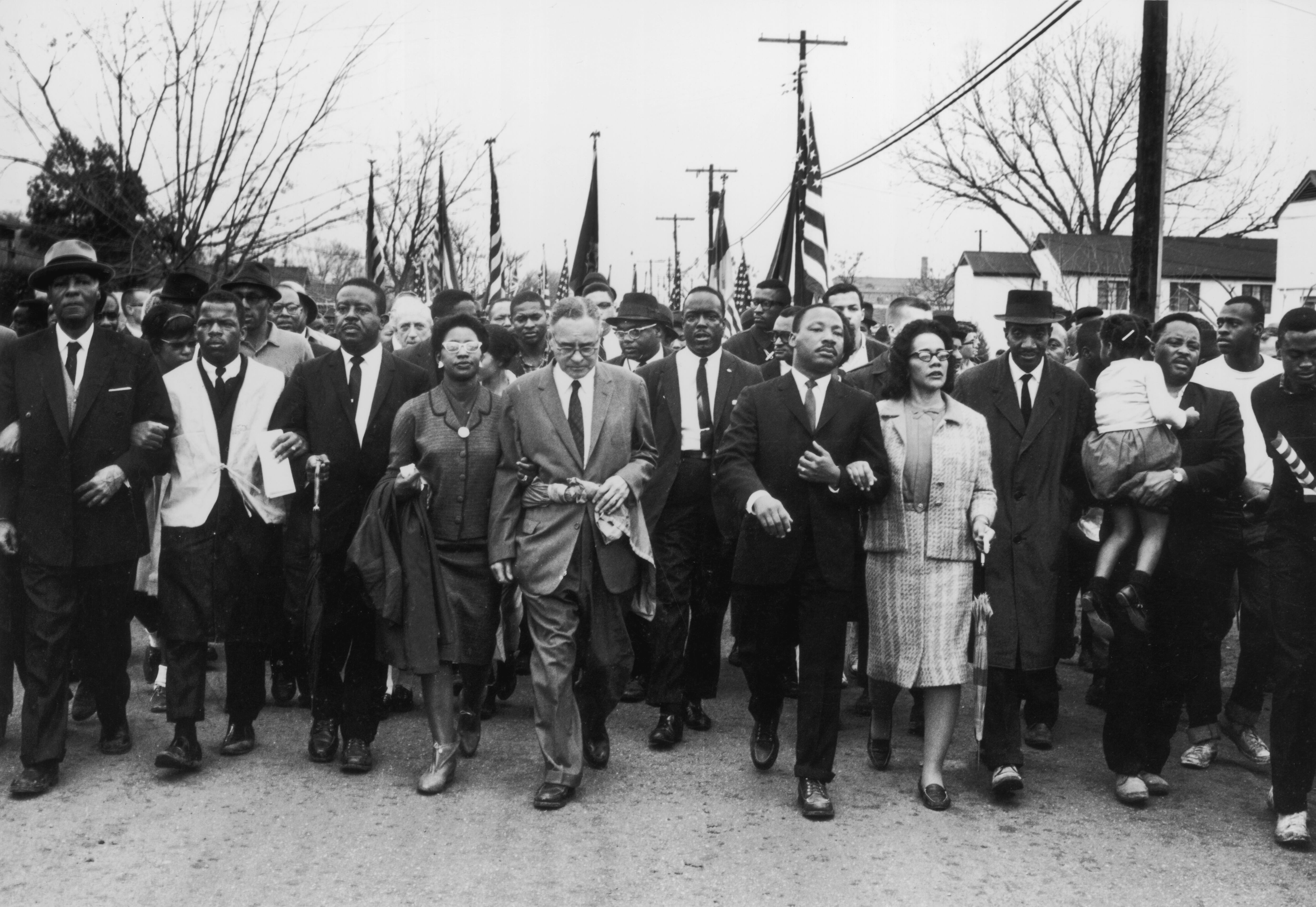Martin Luther King y su esposa Coretta Scott King lideran una marcha por el derecho al voto en Selma, Alabama. En la imagen también aparece Ruth Harris Bunche.