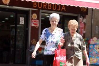 Dos mujeres mayores caminan por una calle de Madrid. 