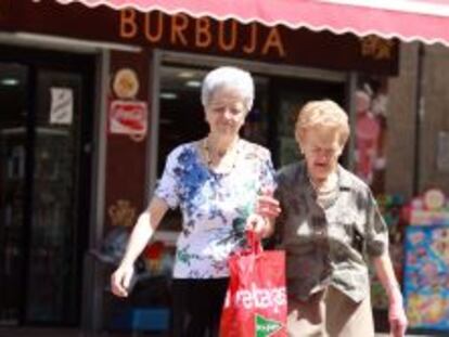 Dos mujeres mayores caminan por una calle de Madrid. 