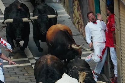 Un corredor evita el pitón de unos de los astados de Fuente Ymbro a su paso por la calle Mercaderes, este miércoles. 
