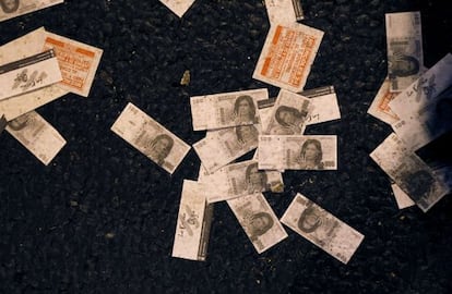 Fake 100-peso bills with a picture of President Cristina Fern&aacute;ndez de Kirchner lie on the ground after a protest outside Congress.