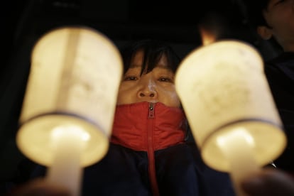 Una activista conservadora surcoreana sostiene velas durante una vigilia para desear una pronta recuperación al embajador de EE UU, Mark Lippert, que fue atacado con un cuchillo en Corea del Sur.
