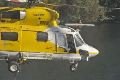 Un helic&oacute;ptero de la empresa Inaer baja a cargar agua en Ourense para combatir el fuego de Cudeiro, el pasado jueves. 