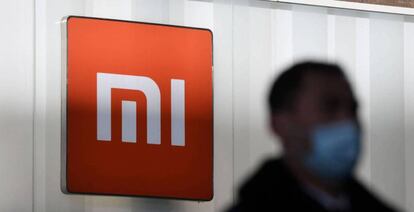 Un hombre pasa en Pekín junto a un logo de Xiaomi.