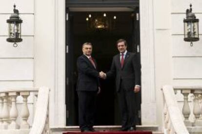 El primer ministro luso Pedro Passos Coelho (d), estrecha la mano de su homólogo húngaro, Viktor Orban, durante su encuentro en el palacio de Sao Bento en Lisboa, Portugal, el 3 de mayo de 2013.