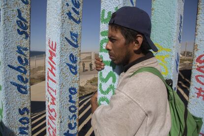 David Salomón, un migrante hondureño, abraza la valla en Tijuana, en la frontera entre México y Estados Unidos, el pasado 14 de noviembre.