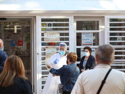 Una sanitaria sale a atender a las numerosas personas que hacen cola en el Centro de Salud Vicálvaro-Artilleros en el distrito de Vicálvaro, en Madrid el 28 de septiembre.