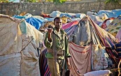 Un miliciano camina entre las tiendas de un campo de desplazados de Mogadiscio. En ciertos lugares de Somalia es más fácil encontrar armas que comida.