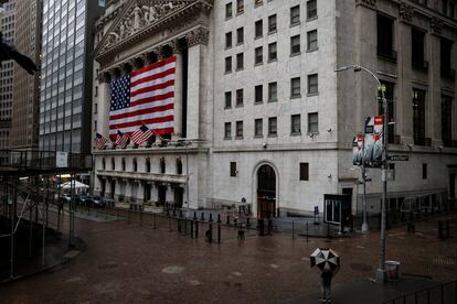 Un peatón camina por una Wall Street casi vacía.