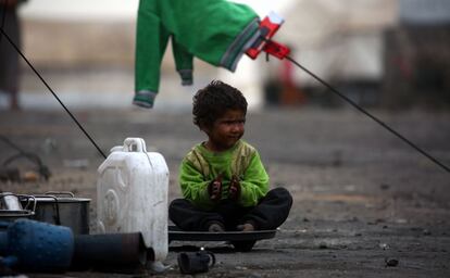 A displaced Syrian child, who fled the countryside surrounding the Islamic State (IS) group stronghold of Raqa, sits at a temporary camp in the village of Ain Issa on April 28, 2017. / AFP PHOTO / DELIL SOULEIMAN