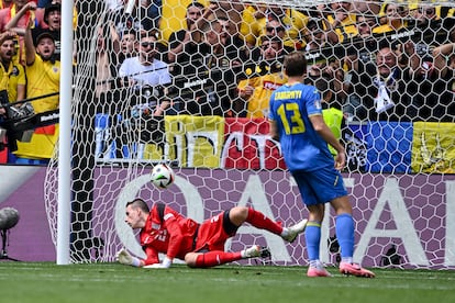 Los ucranios Andrei Lunin e Illia Zabarnyi observan el balón entrar en segundo gol de Rumanía.