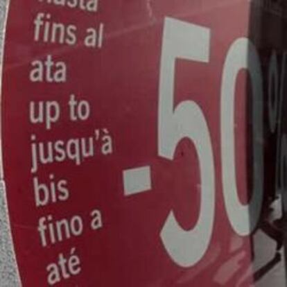 Cartel de un comercio con descuentos en una céntrica calle de Madrid, con la Puerta del Sol al fondo