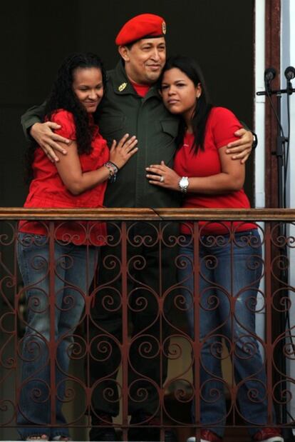 Hugo Chávez kisses daughter María Gabriela and embraces her sister Rosa Virginia on Monday.