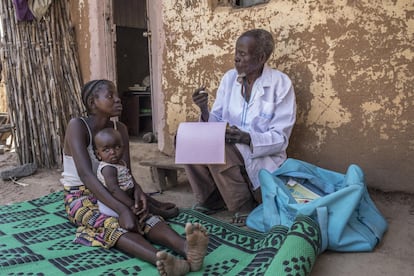 Las comunidades rurales de zonas remotas son las que más alejadas están de recibir una buena diagnosis y también de un tratamiento adecuado para acabar con la neumonía. Loveleen Anex, de 25 años, sostiene a su hija de nueve meses, Ensteen Anex, junto al sanitario y promotor de salud de Unicef, Benjamin Daniels, de 66 años, que examina al niño verificando posibles signos de neumonía, en la aldea de Jarede, cerca de la ciudad de Yola, en el estado de Adamawa, al noreste de Nigeria.