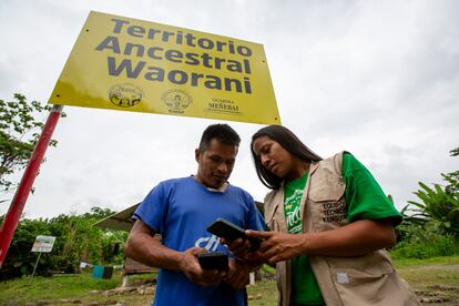  Kleber Andi y Laura Enqueri miran una aplicación de celular donde se coloca información de las posibles amenazas a la selva amazónica.
