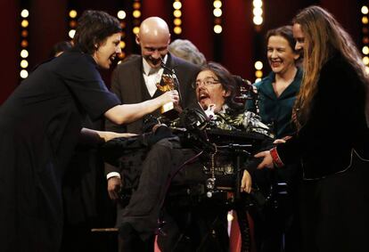 Adina Pintilie comparte su Oso de Oro con sus actores T&oacute;mas Lemarquis (detr&aacute;s) y Christian Bayerlein, en silla de ruedas.