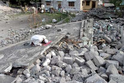 Un hombre reza entre los escombros de un edificio destruido por el terremoto en Muzaffarabad.