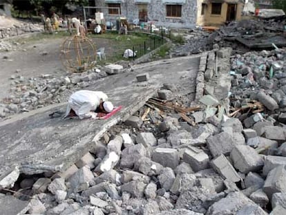 Un hombre reza entre los escombros de un edificio destruido por el terremoto en Muzaffarabad.