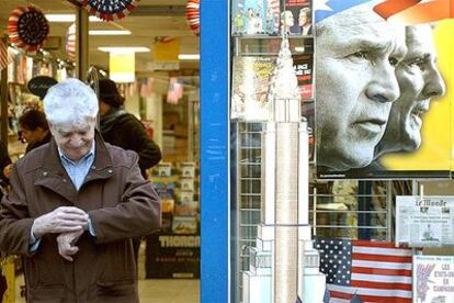 Un hombre sale de una tienda de periódicos, en París, decorada con banderas de EE UU y carteles de las elecciones presidenciales.