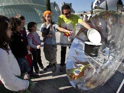 Greenpeace enseña a varios escolares cómo funciona una cocina solar.