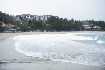 La playa de la Bahía Principal en Puerto Escondido hoy. Las playas de la costa oaxaqueña lucían nubladas y con el mar agitado la mañana de este lunes, mientras los pobladores se abastecían de agua y alimentos y protegían viviendas y comercios. Las clases y actividades no esenciales fueron suspendidas en la zona afectada.