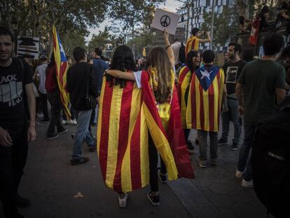 Dos jóvenes, una con la bandera independentista catalana y otra con la bandera española, caminan abrazadas durante la protesta del pasado martes en Barcelona.
