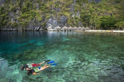 Banhistas praticam snorkel em frente a um resort em El Nido, nas Filipinas.