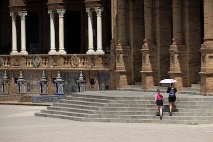 Dos jóvenes se protegen con un paraguas del sol, este viernes en Sevilla.