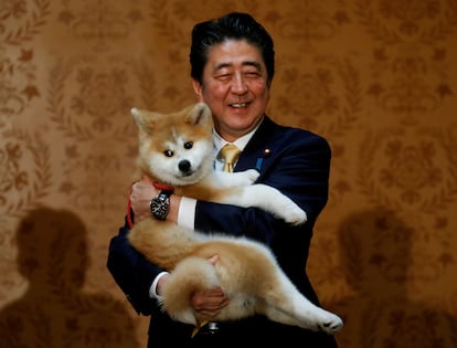 元日本の首相は2018年5月26日、ロシアのモスクワで子犬とポーズをとった。