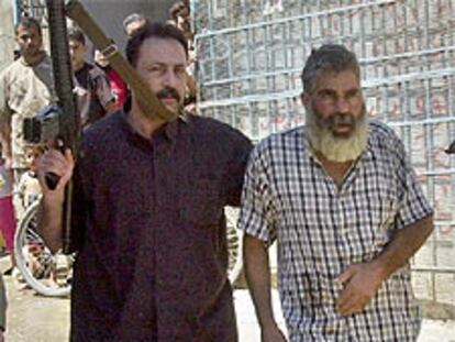 Milicianos palestinos empujan a Mohamed Rafia Daragmeh hasta la plaza mayor de Qabatia.
